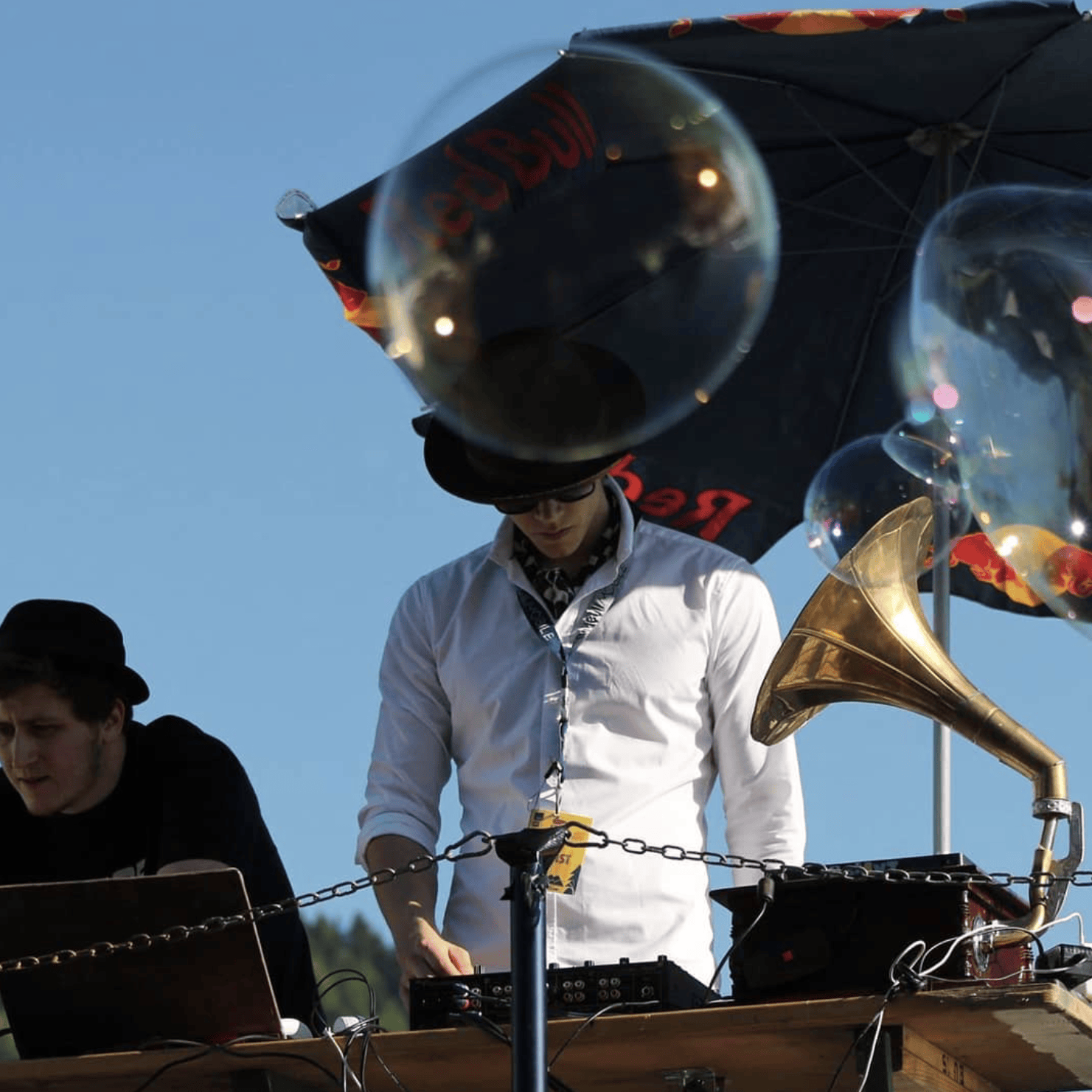 Electro swing DJ performing at a lively music festival in austria with live saxophone